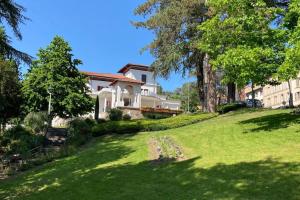 ein Haus auf einem Hügel mit einem grünen Hof in der Unterkunft La Villa Coisy in Saint-Galmier