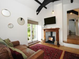 a living room with a couch and a fireplace at Pheasant Barn in Liskeard