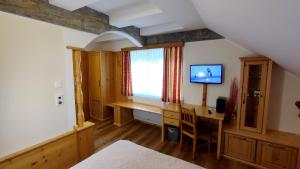 ein Schlafzimmer mit einem Schreibtisch und einem TV in einem Zimmer in der Unterkunft Lorenzer Schlafstubn in Sankt Lorenzen im Mürztal