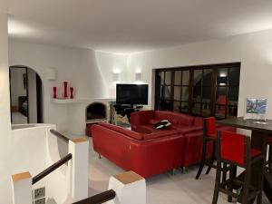 sala de estar con sofá rojo y chimenea en Casa Colina, en San Antonio