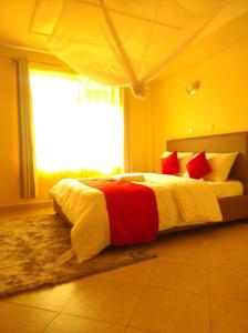 a bedroom with a large bed with red and white pillows at Musundi Luxury Homes in Kakamega