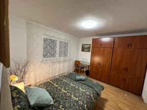 ein Wohnzimmer mit einem Bett und einem Holzschrank in der Unterkunft Podkarpacka 50 in Rzeszów