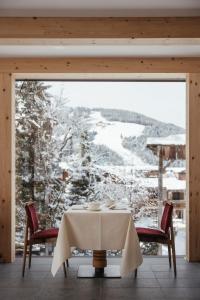 una mesa en una habitación con vistas a una montaña nevada en Hotel Chalet Corso, en San Vigilio Di Marebbe