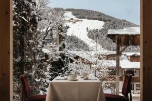 stół z widokiem na pokrytą śniegiem górę w obiekcie Hotel Chalet Corso w mieście San Vigilio di Marebbe