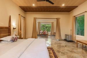 a bedroom with a large bed and a large window at Jungle King Resort in Kānha