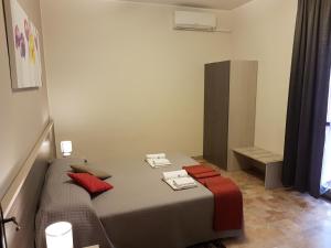 a bedroom with a bed with red pillows and a mirror at B&B Monté in Montesilvano