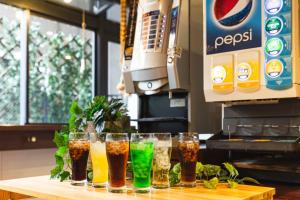 a row of glasses of drinks on a table at HOTEL RELIEF Namba Daikokuchou in Osaka
