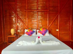 two towels on a bed in a room at Winyanz Tambayan Tourist Inn in Siquijor