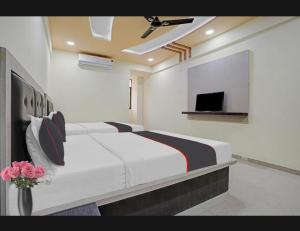 a room with three beds and a tv at Hotel GGC INN in Ahmedabad