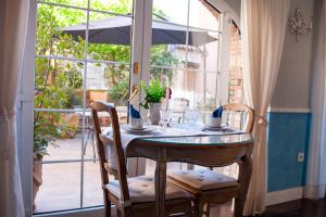 a table with chairs and an umbrella in front of a window at Casa Rural La Pajarona in Siruela