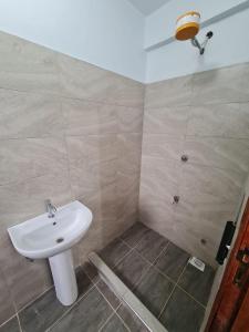 W łazience znajduje się umywalka i prysznic. w obiekcie Cossy homes kericho grey point w mieście Kericho