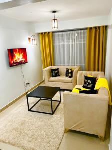 a living room with a couch and a coffee table at Cossy homes kericho grey point in Kericho