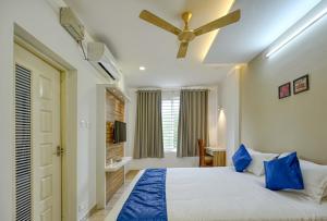 Perumayan Arcade في كوتشي: غرفة نوم بسرير ومروحة سقف