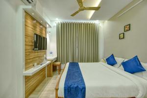 a bedroom with a large bed and a television at Perumayan Arcade in Cochin