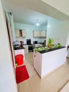 a kitchen with white cabinets and a red rug at Cossy homes kericho grey point in Kericho
