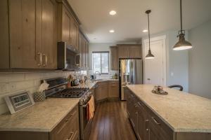 a kitchen with wooden cabinets and a counter top at Family Vacation-Crater Hot Spring, Tubing & Ice Skating-Kanton apts in Midway +31 photos