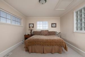 1 dormitorio con 1 cama y 2 ventanas en Family Getaway-Hot Tub, Ice Castles & Tubing HS home, en Midway