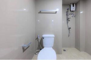 La salle de bains blanche est pourvue d'une douche et de toilettes. dans l'établissement PT Residence Bearing, à Bangna