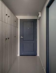 una puerta azul en una habitación con armarios de madera en PT Residence Bearing en Bangna