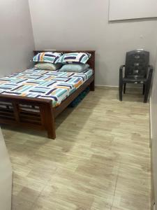 um quarto com uma cama e uma cadeira em Vinoth home stay service apartment em Chennai