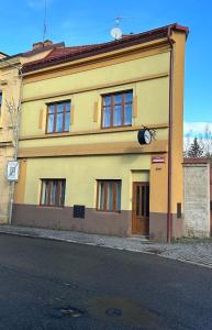 een geel gebouw met een klok aan de zijkant bij AbC in Unhošť