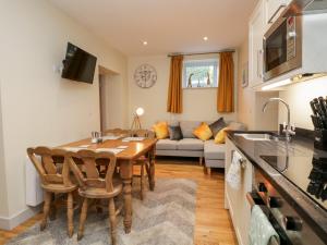 a kitchen and a dining room with a table and a couch at Granary in Ulverston