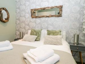 two beds in a bedroom with a mirror on the wall at Granary in Ulverston