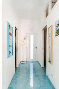 - un couloir doté de carrelage bleu et de murs blancs dans l'établissement Casa Mare me', à Mondello