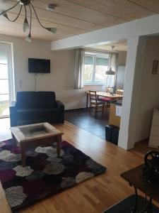 sala de estar con sofá y mesa en Ferienwohnung Steinrücken en Grub am Forst