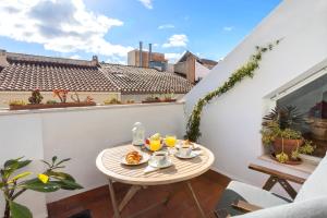 uma pequena mesa numa varanda com comida em ÁTICO amplio y luminoso SOHO (Barrio de las Artes) em Málaga