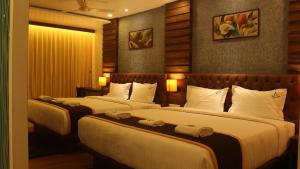 Habitación de hotel con 2 camas y almohadas blancas en HOTEL IDHAYA, en Port Blair