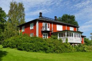 una casa naranja y blanca en un campo verde en Sundets Gård - Bed & Breakfast en Kopparberg