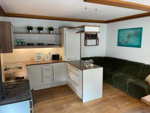a kitchen with a green couch in a living room at Holzhaus Falkenstein in Schwarzau im Gebirge
