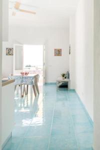 a room with a table and a blue tile floor at Casa Mare me' in Mondello