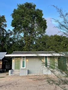 uma pequena casa branca com uma porta verde em Casa Lena em Cherating