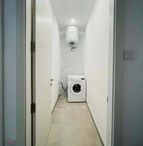 Un pasillo con una lavadora en una habitación. en Spacious and beautiful flat in Gzira, en Il-Gżira