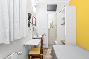 Habitación pequeña con cama y lavamanos en Hostal Santa Ana, en Barcelona