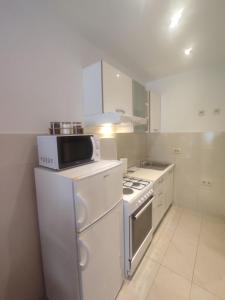 cocina blanca con fogones y microondas en Apartments Deni 10, en Dubrovnik