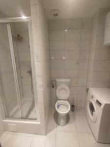 biała łazienka z toaletą i prysznicem w obiekcie Apartments Deni 10 w Dubrowniku