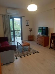 een woonkamer met een bank, een tafel en een tv bij Klimataria B2 in Pissouri