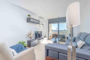 a living room with a blue couch and a tv at Goldhome - Cristallmar in Empuriabrava