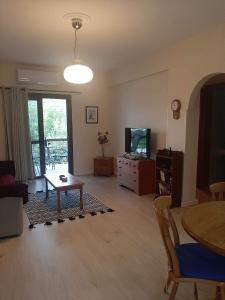 a living room with a table and a tv at Klimataria B2 in Pissouri