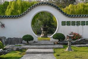un arco en un jardín con un camino de piedra en Suanphung Bonsai Village, en Ban Bo Wi