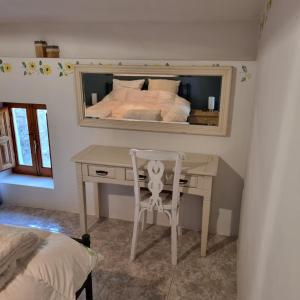 1 dormitorio con escritorio y 1 cama con espejo en Cortijo naturista con vistas -Clothing optional en Oria