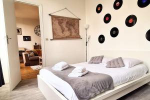 um quarto com uma cama com discos na parede em My Conciergerie by Lucy Violin - Le Gambetta em Angoulême