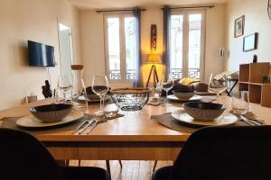 uma mesa de madeira com taças e copos de vinho em My Conciergerie by Lucy Violin - Le Gambetta em Angoulême