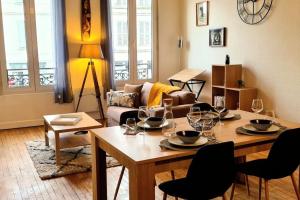 uma sala de estar com uma mesa com copos de vinho em My Conciergerie by Lucy Violin - Le Gambetta em Angoulême