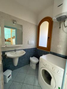 a bathroom with a washing machine and a sink at Casa delle Farfalle in Chia