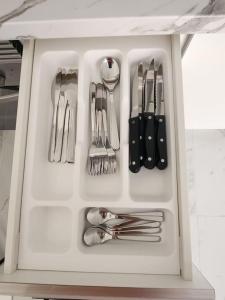 a white drawer filled with utensils in a kitchen at Appartamento vista oceano a pochi passi dal mare in Playa Fañabe