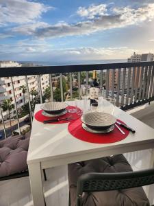 un tavolo bianco con piatti e bicchieri su un balcone di Appartamento vista oceano a pochi passi dal mare a Playa Fañabe